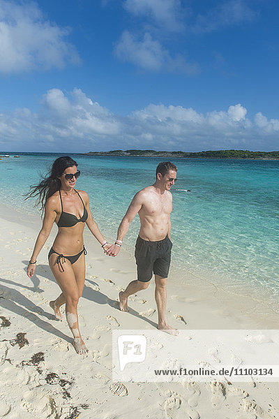 Couple walking on a white sand beach  Exumas  Bahamas  West Indies  Caribbean  Central America