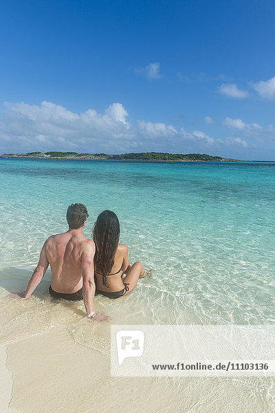 Paar an einem weißen Sandstrand im türkisfarbenen Wasser der Exumas  Bahamas  Westindische Inseln  Karibik  Mittelamerika