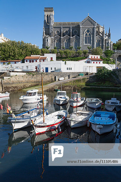 Small port with traditional fishing boats and Eglise Sainte Eugenie in Biarritz  Pyrenees Atlantiques  Aquitaine  France  Europe