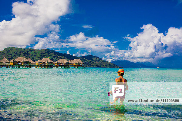 Frau watet im Wasser  Le Taha'a Resort  Tahiti  Französisch-Polynesien  Südpazifik  Pazifik