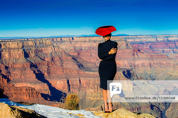 Frau mit rotem Hut posiert am Rande des Grand Canyon  UNESCO-Welterbe  Arizona  Vereinigte Staaten von Amerika  Nordamerika