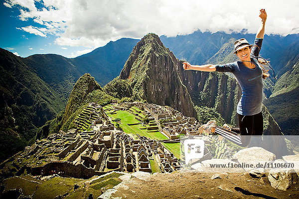 Laura Grier springt in den Ruinen von Machu Picchu  Peru  Südamerika