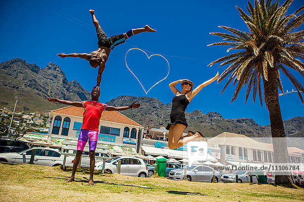 Laura Grier jumping with African acrobats  Camps Bay  South Africa  Africa