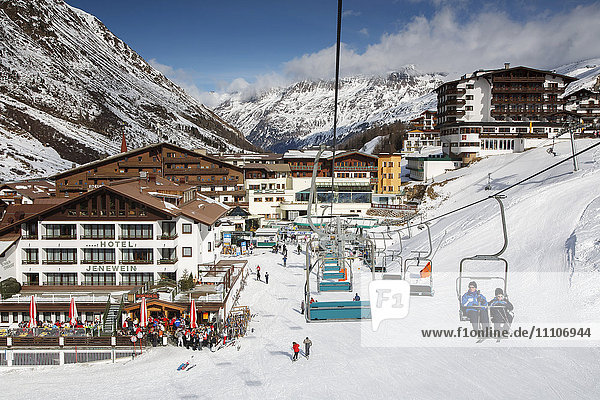 Das alpine Skidorf Obergurgl mit Skifahrern  die sich ausruhen  während andere mit Sesselliften zu den Pisten in den Otztaler Alpen fahren  Tirol  Österreich  Europa
