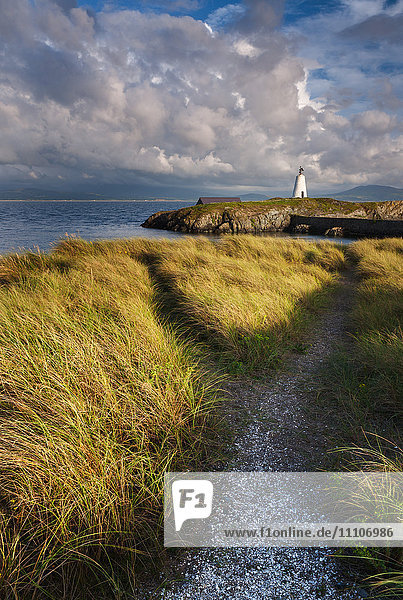 Ein Küstenpfad führt zum Leuchtturm Twr Mawr auf der Insel Llanddwyn  Anglesey  Wales  Vereinigtes Königreich  Europa