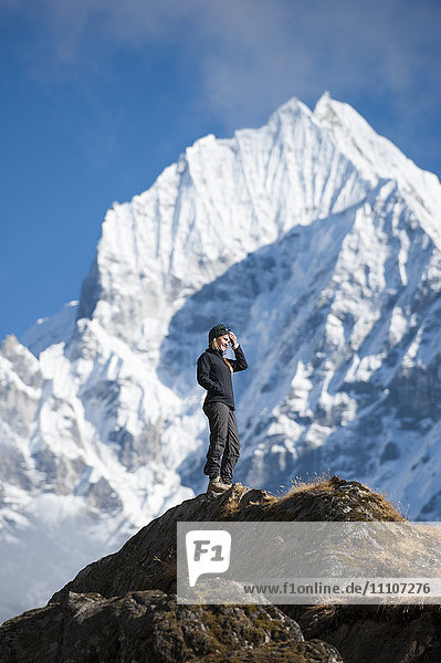 Ein Trekker genießt die Aussicht über Namche in der Everest-Region mit Blick auf den Thermserku in der Ferne  Himalaya  Nepal  Asien