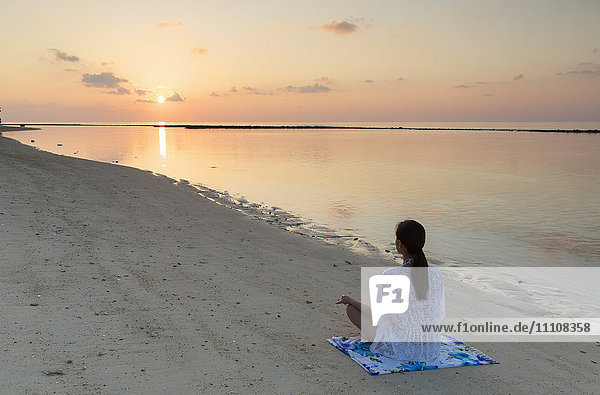 Frau übt Yoga bei Sonnenaufgang  Insel Rasdhoo  Nördliches Ari-Atoll  Malediven  Indischer Ozean  Asien