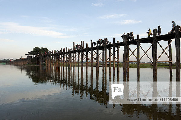 Menschen beim Überqueren der U Bein-Brücke  die von 984 Teakholzpfählen gestützt wird  über eine 1 2 km lange Strecke über den Thaumthaman-See  Mandalay  Myanmar (Birma)  Asien