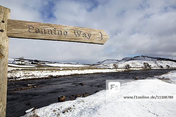 Sign for the Pennine Way walking trail on snowy landscape by the River Tees Upper Teesdale County Durham England United Kingdom Europe