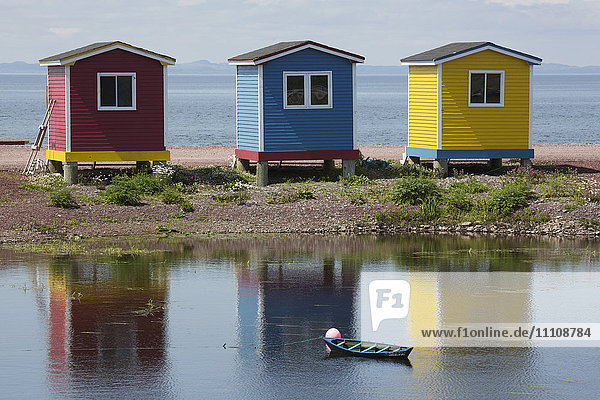 Colourfully painted huts by the shore of the Atlantic Ocean at Heart's Delight-Islington in Newfoundland and Labrador Canada North America