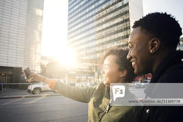 Teenager nimmt Selfie mit Freund durch Smartphone durch die Stadt Straße