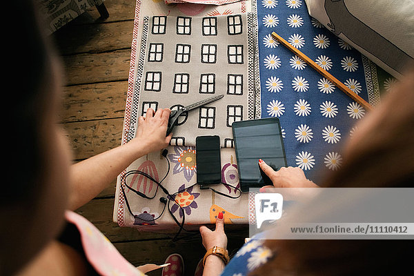 Besitzer zeigt und zeigt auf digitales Tablett während der Arbeit im Textilgeschäft