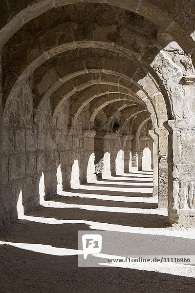 Panorama of semicircular stone seats at Aspendos Amphitheatre with upper gallery arches and stage Turkey