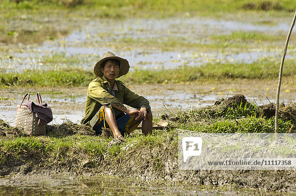 Asien  Myanmar  Taunggyi  Inle-See  Mann ruht sich nach der Arbeit im Reisfeld aus
