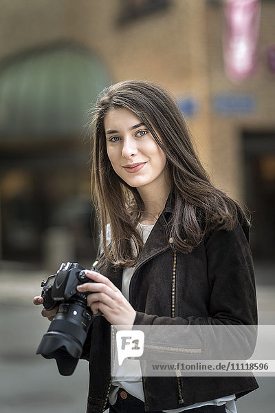 Junge Frau hält Kamera