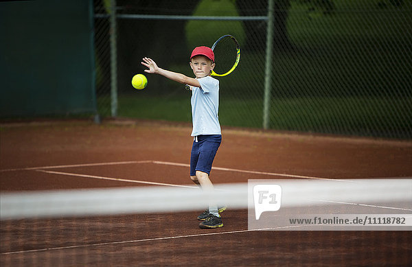 Junge spielt Tennis