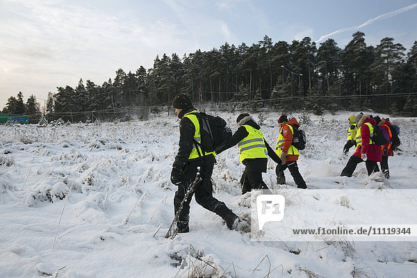 Schweden  Uppland  Upplands Vasby  Volunteers of Missing people organisation walking on field covered with snow