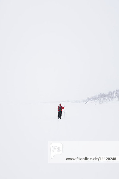 Schweden  Lappland  Riksgransen  Frau geht mit Wanderstöcken durch den Schnee