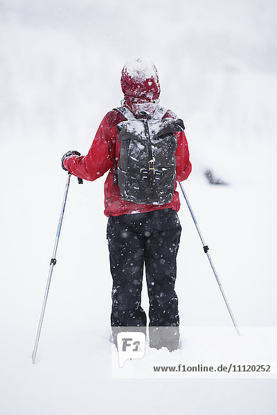 Schweden  Lappland  Riksgransen  Frau geht mit Wanderstöcken durch den Schnee