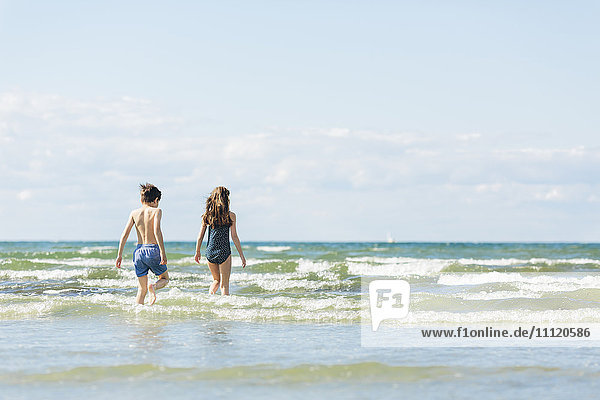 Schweden Oland Kopingsvik Mädchen (10-11) und Junge (8-9) die ins Meer gehen.