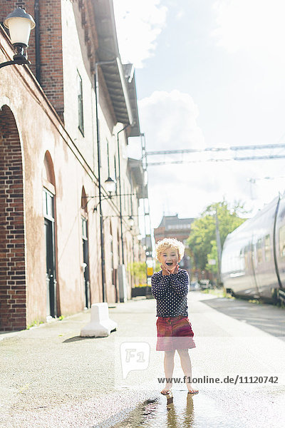 Sweden Skane Ystad Girl (4-5) walking on sidewalk in city