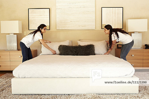 Hispanic women making bed