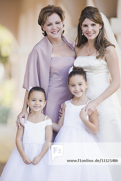 Multi-ethnic bride with mother and flower girls