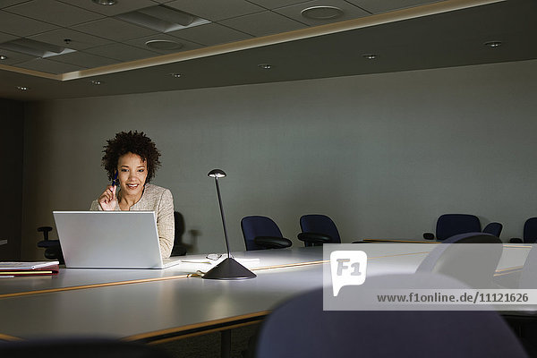 African businesswoman working on laptop in conference room