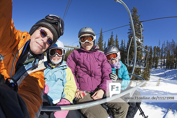 Familie fährt gemeinsam Skilift