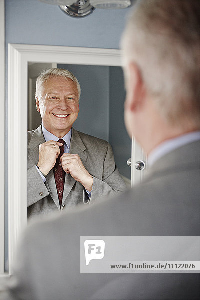 Geschäftsmann richtet seine Krawatte im Spiegel