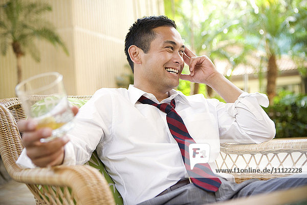Smiling mixed race man drinking on patio