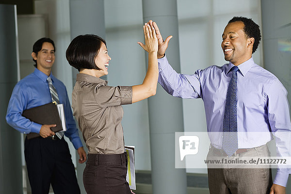 Multiethnische Mitarbeiter geben sich im Büro die Klinke in die Hand