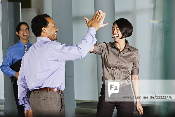 Multiethnische Mitarbeiter geben sich im Büro die Klinke in die Hand