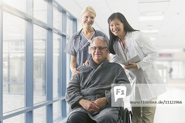 Arzt und Krankenschwester lächelnd mit Patient im Krankenhaus