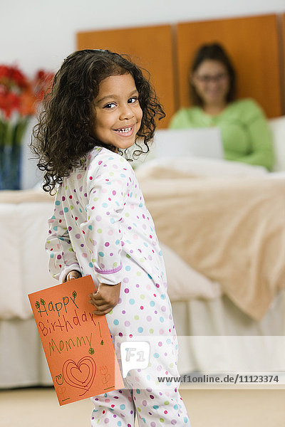 Hispanic girl with birthday card for mother