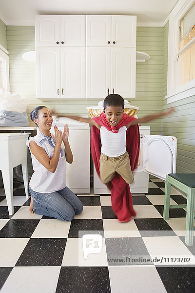 Gemischtrassige Mutter und Sohn spielen mit Wäsche