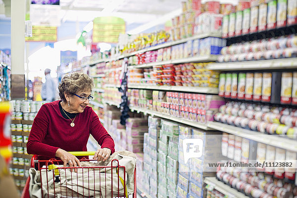 Ältere hispanische Frau beim Einkaufen in einem Lebensmittelladen