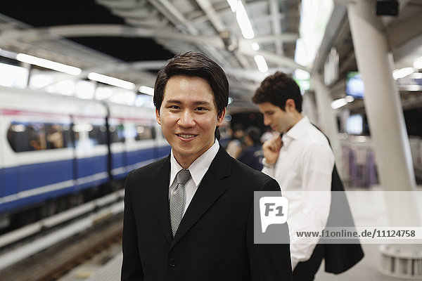 Businessmen waiting on platform for subway train