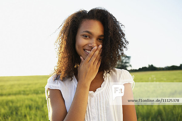 African woman covering mouth with hand while smiling