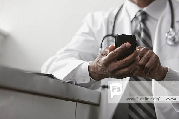 Afroamerikanischer Arzt sendet Textnachrichten mit seinem Handy