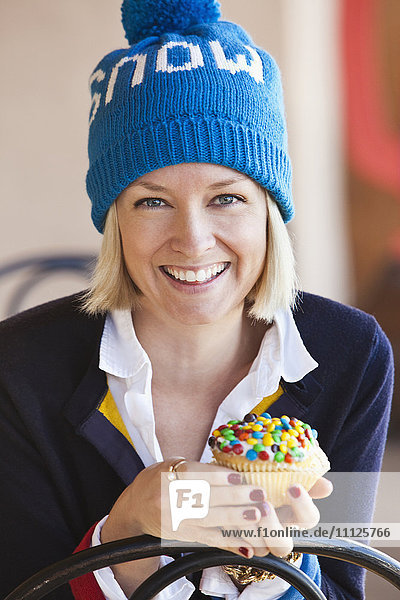 Caucasian woman eating cupcake