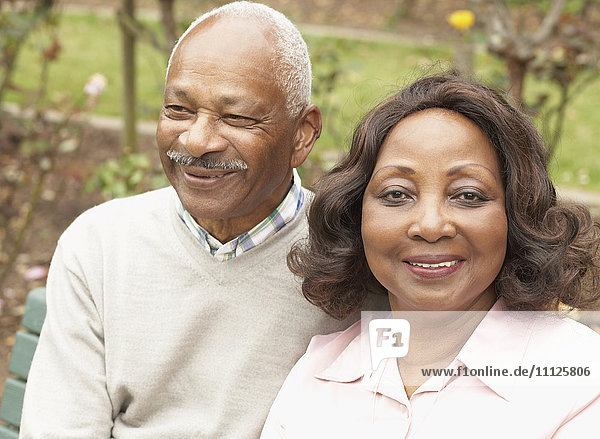 Senior African couple hugging and smiling outdoors