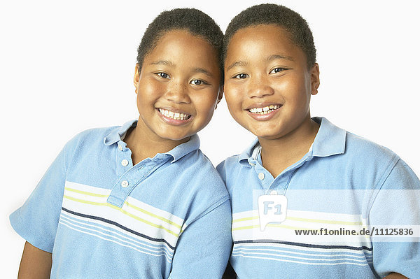 Junge afrikanische Zwillingsbrüder  die sich umarmen und lächeln