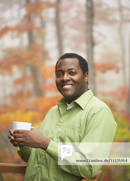African man holding cup of coffee