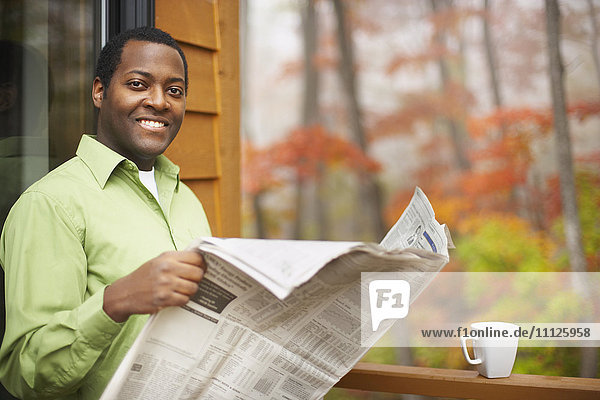 Afrikanischer Mann liest Zeitung im Freien