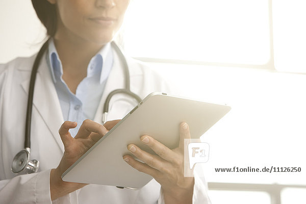 Hispanischer Arzt mit digitalem Tablet