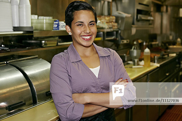 Hispanische Kellnerin lächelt im Restaurant