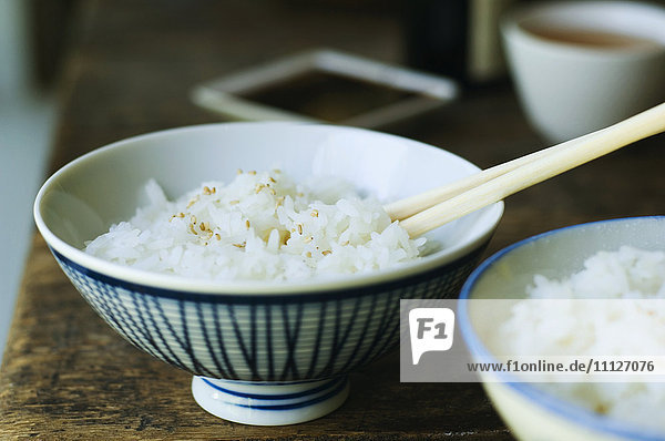 Schale mit Reis und Stäbchen