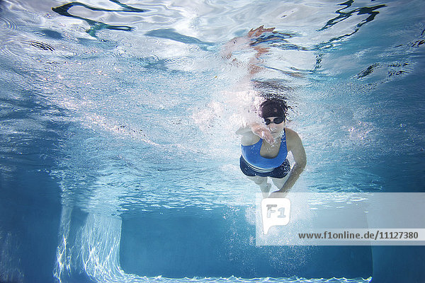 Kaukasische Frau schwimmt im Schwimmbad