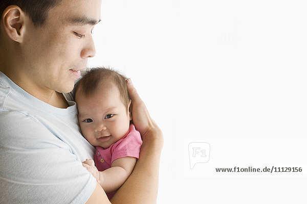 Chinese father holding baby daughter